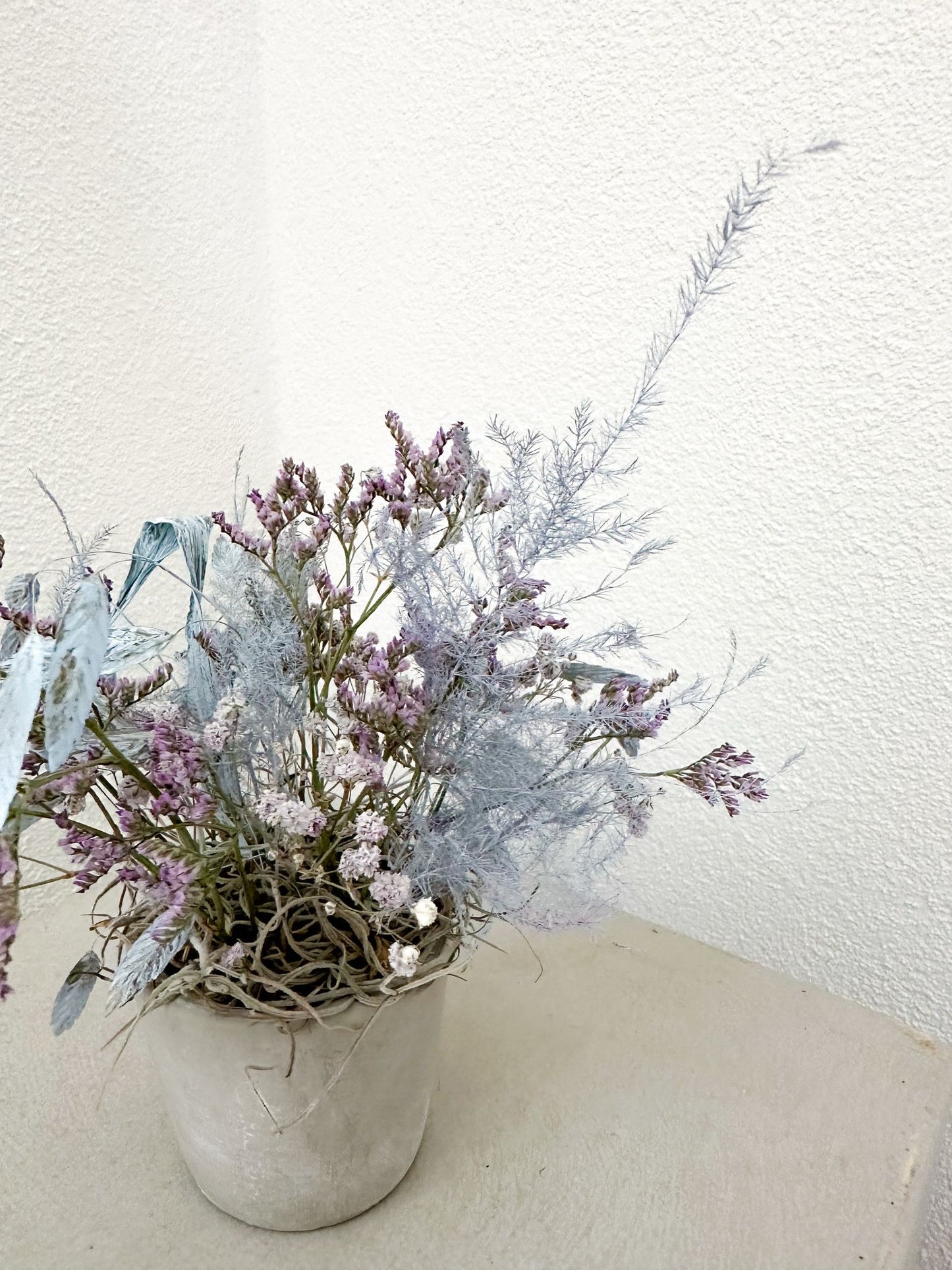Dekoratives Trockenblumenbouquet mit pastelligen Blau- und Violetttönen – minimalistisch inszeniert.