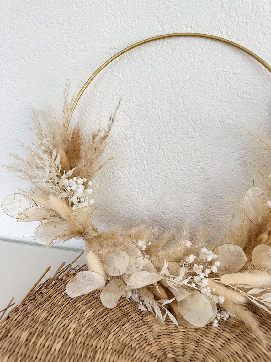 Nahaufnahme des 30 cm großen Daniela Hoops, der die sorgfältig ausgewählten Trockenblumen in natürlichen Beigetönen zeigt, die harmonisch mit dem goldenen Metallring verschmelzen und ein Gefühl von Wärme und handwerklicher Qualität vermitteln.