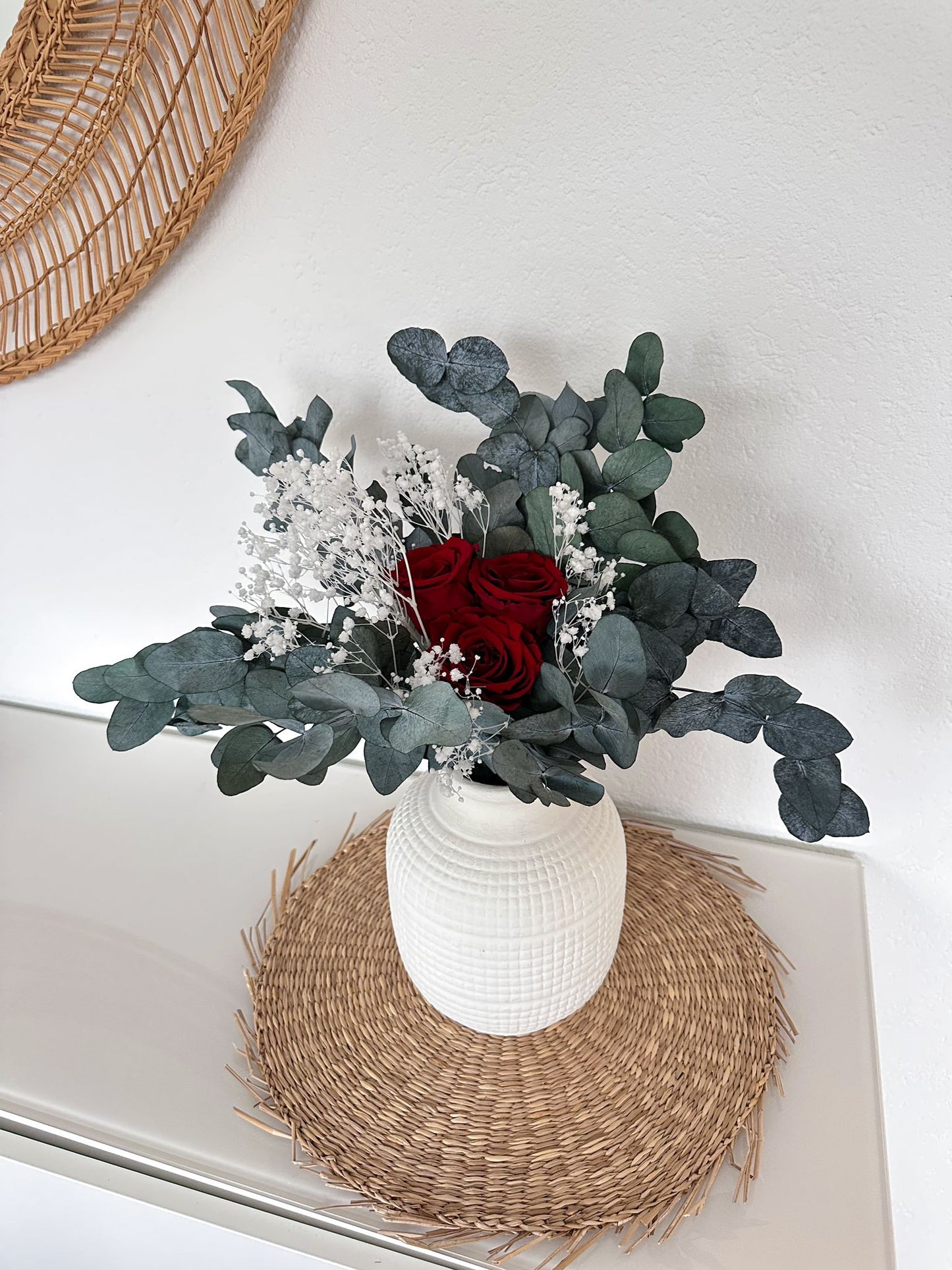Emina Bouquet auf einem runden Rattan-Untersetzer, ideal für eine minimalistische Einrichtung.