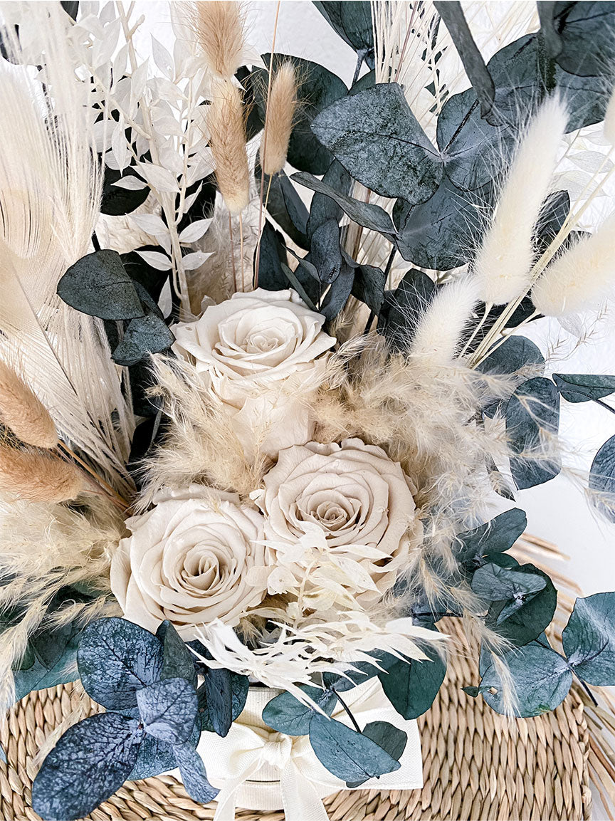 Eine Flowerbox mit Trockenblumen und stabilisierten Rosen. Nahaufnahme Rosen.