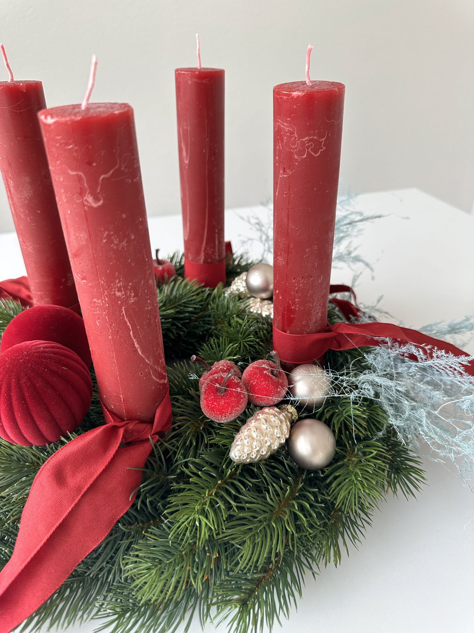 Festlicher Adventskranz in Rot und Grün auf weissem Hintergrund