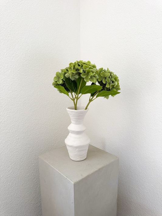 Minimalistisches Arrangement mit drei grünen Kunsthortensien, dekorativ platziert in weisser Vase zur Inspiration (nicht im Lieferumfang).