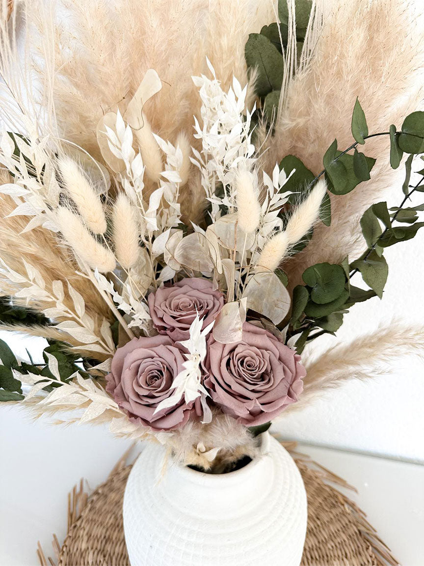 Nahaufnahme des Jael Bouquets, die die Textur und die natürlichen Farben der Pfaufedern und des Ruscus hervorhebt.