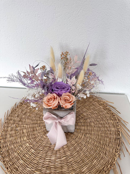 Der 'Mama Topf' mit stabilisierten Rosen in sanften Tönen, präsentiert als perfektes Muttertagsgeschenk auf einem eleganten Strohuntergrund.