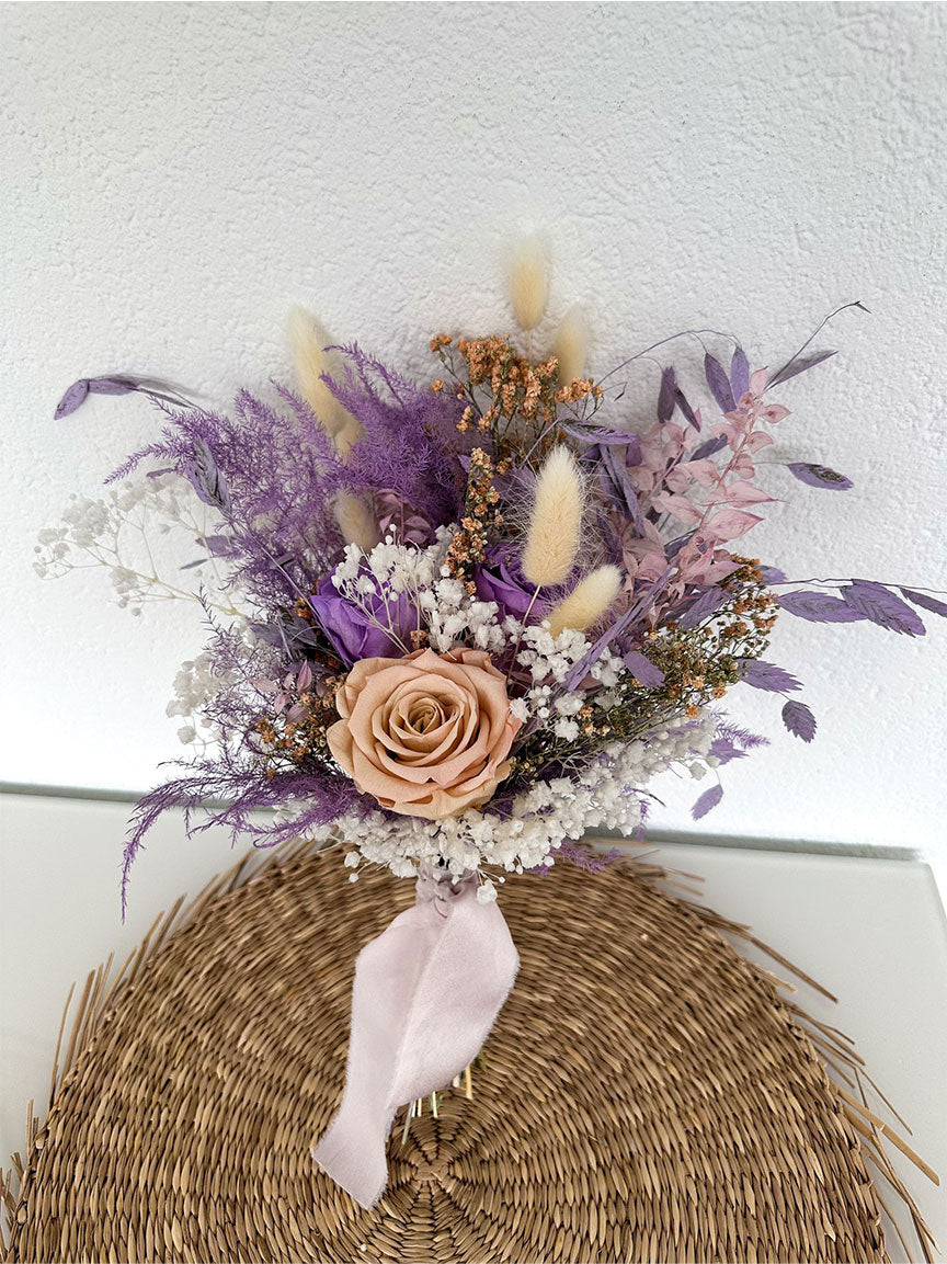 Das 'Mama Bouquet mit 3 Rosen' ruht auf einer Rattanunterlage, ein Bild ewiger Schönheit und natürlicher Anmut.