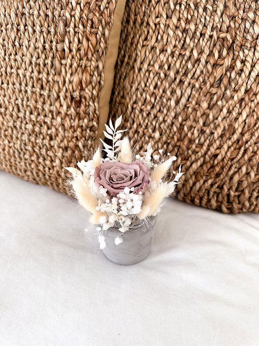 Handgefertigtes Mini Gesteck 'Mama', kunstvoll arrangiert mit Rosen und Trockenblumen auf einem natürlichen Untergrund.