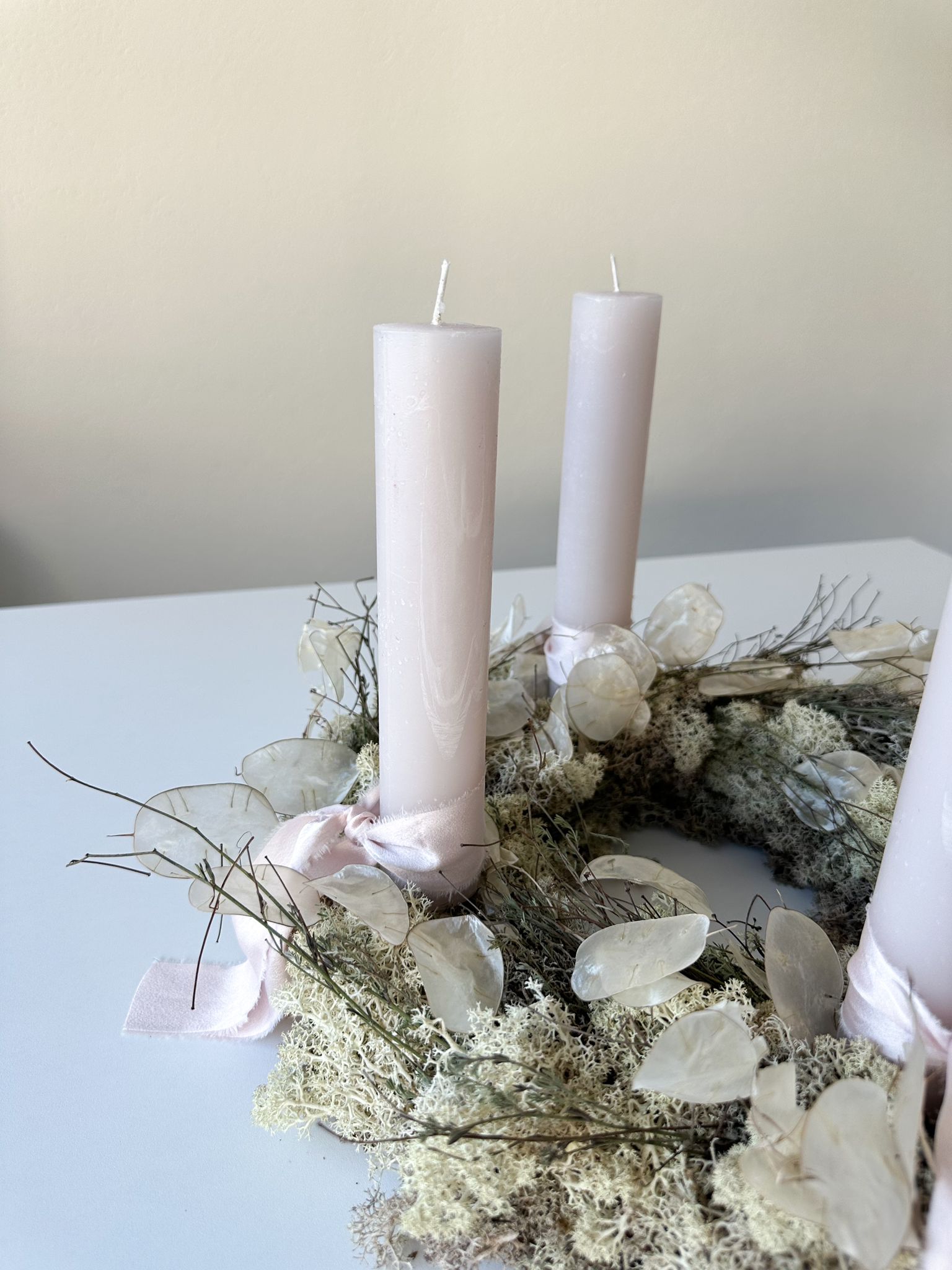 Detailaufnahme des Adventskranzes Veronika mit Lunaria-Blättern und Moosstruktur.