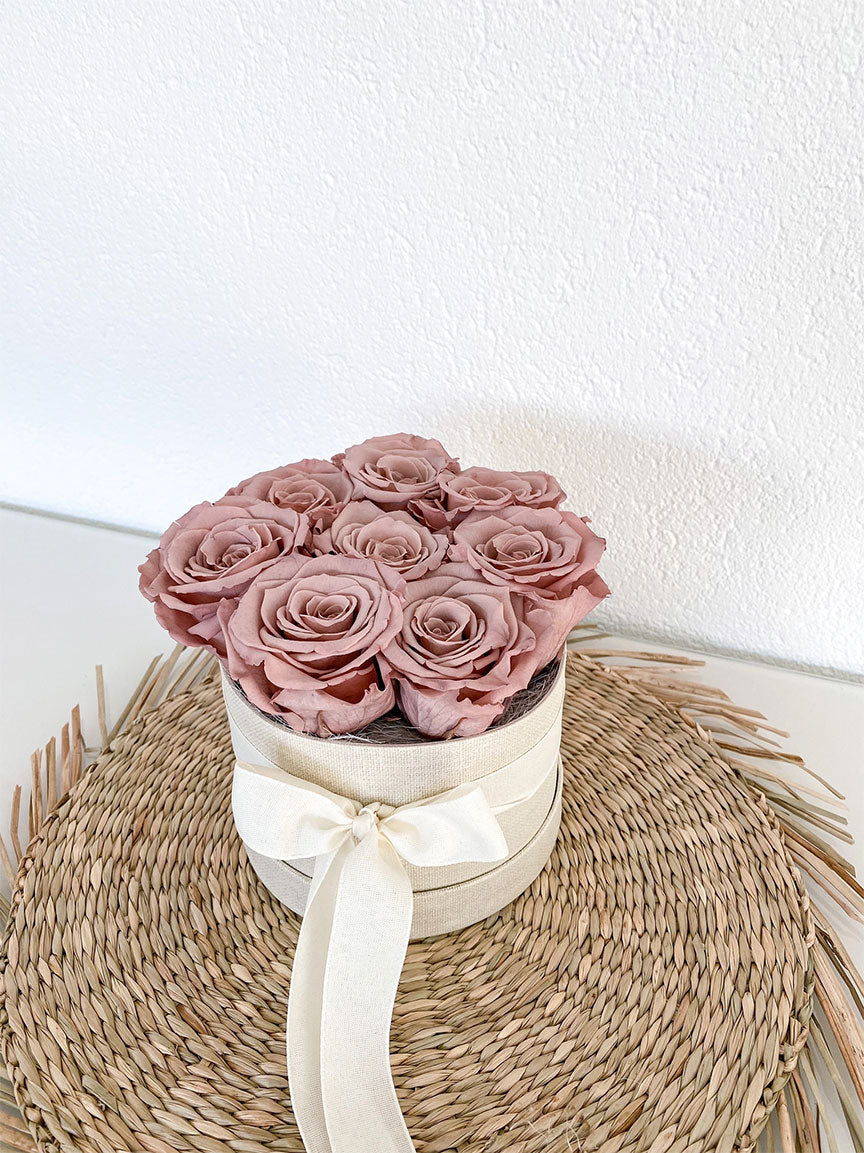 Eine Rosenbox mit acht stabilisierten Rosen in einem hellen Schokoladen braun. Nahaufnahme.