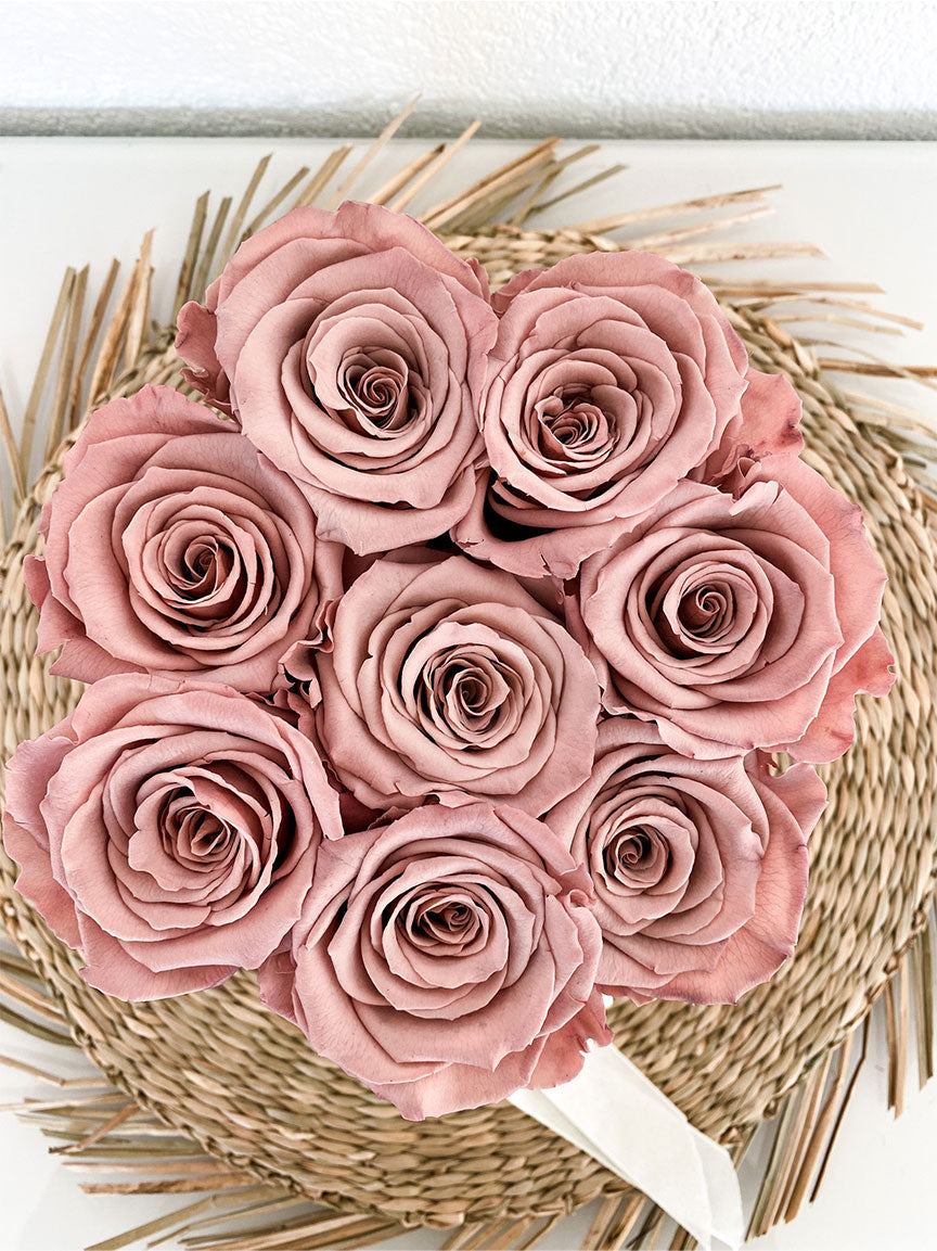 Eine Rosenbox mit acht stabilisierten Rosen in einem hellen Schokoladen braun. Aufnahme von oben, Rosen. 